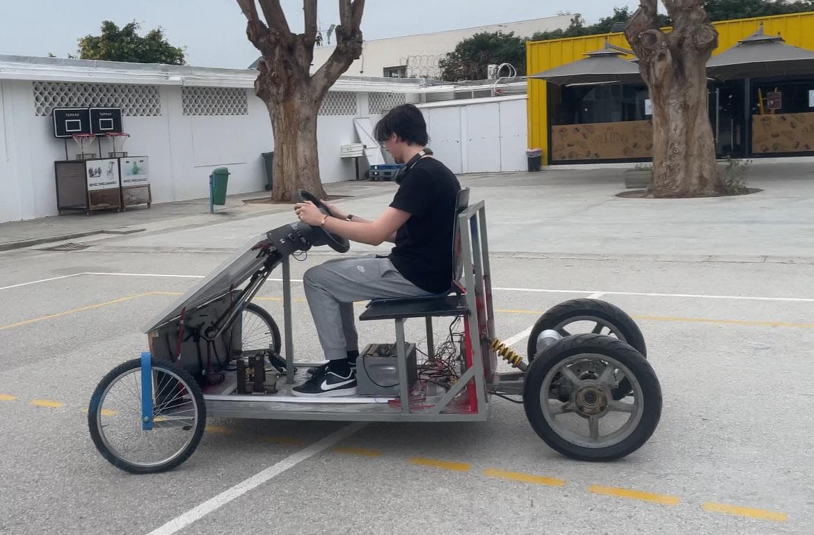 Side view of a person seated at the wheel of the vehicle prototype outdoors
